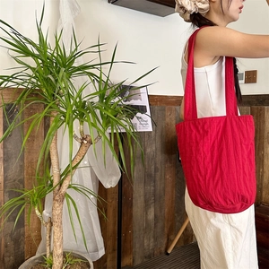 Detail van rode geplooide shopper met verticale textuur en schouderband voor dagelijks gebruik