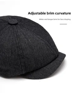 Detail of black denim newsboy cap with a wide foldable brim for face shaping effects