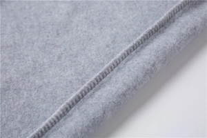 Vue détaillée de la texture du tissu de sweat gris clair et coutures de finition précises