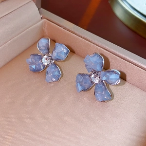Dettaglio ravvicinato di orecchini a fiore in cristallo blu con zirconi brillanti