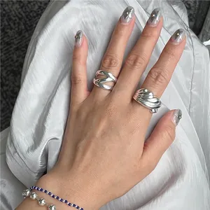 Macro shot of 925 silver twist ring and beaded bracelets on white silk background