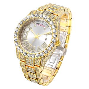 Macro shot of gold iced out watch face featuring day-date display and sparkling crystals