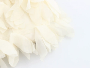 Close-up of creamy white multi-layered ruffles with sheer mesh fabric texture