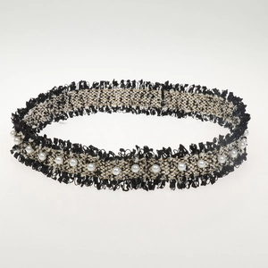 Detailed view of handmade black and white braided rope with elegant pearl accents