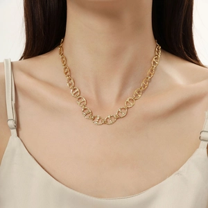 Primo piano di una collana a catena d'oro a maglie larghe indossata da una modella con stile