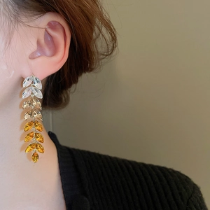 Macro view of gradient crystal leaf tassel earrings on model with high quality details
