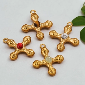Detail of four gold-plated cross pendants with natural tiger eye and colorful stones