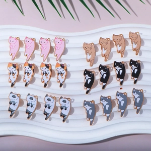 Assorted cartoon cat alloy charms for DIY earrings on a ripple ceramic tray