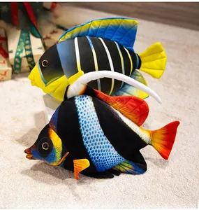 Detailed view of colorful plush tropical fish toys with striped patterns on a soft carpet