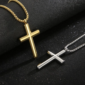 Minimalist gold and silver stainless steel cross necklaces on a textured black background