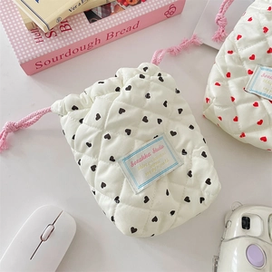 Quilted heart pattern drawstring camera pouch shown with aesthetic lifestyle accessories