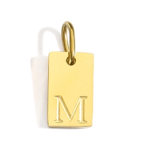Detail of gold-plated stainless steel rectangular pendant featuring engraved letter M