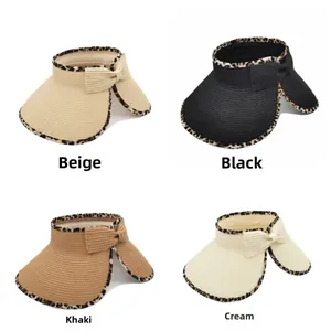 Detailed view of four straw sun visors in beige, black, khaki, and white with leopard trim