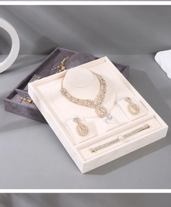 Top-down view of beige velvet jewelry display trays with necklace and ring slots