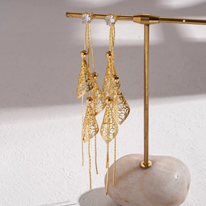 Close-up of 18K gold plated hollow leaf tassels and sparkling cubic zirconia earrings