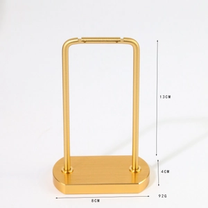 Golden metal earring display stand with oval base for jewelry photography and branding