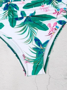 Detail der Bikinihose mit tropischem Blattmuster und grünen genähten Kanten