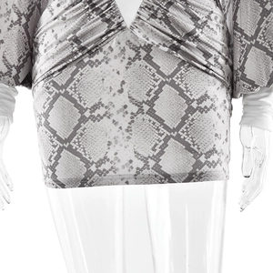 Close-up of ruched mini skirt detail with snakeskin print and soft polyester fabric