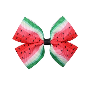 Detailed view of handmade bow hair clip with vibrant red and green watermelon print
