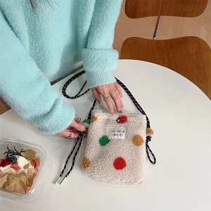 Detail of plush off-white lamb wool bag with colorful polka dots and drawstring