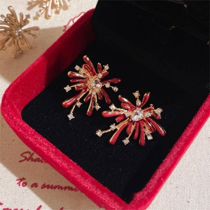 Detail of red firework stud earrings with crystals on a jewelry display case