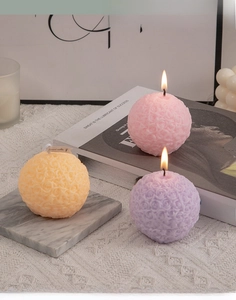 Detailed view of spherical rose flower scented candles in pink, purple and orange colors
