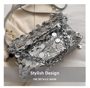Detailed macro view of sparkling silver sequins and chunky metal chain on a luxury handbag