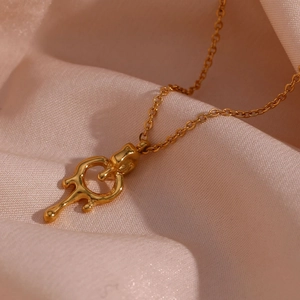 Macro shot of 18K gold plated lava pendant necklace on smooth pink silk background