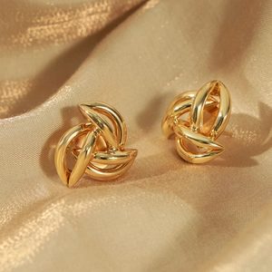 Minimalist gold spiral knot earrings on elegant silk background, hip hop jewelry