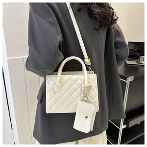 White quilted crossbody bag with matching coin purse and adjustable strap shown on shoulder