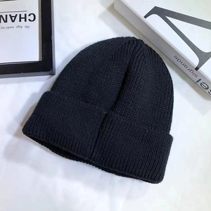 Detailed close-up of a black ribbed knit beanie with high-quality warm texture detail