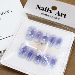 Purple gradient press-on nails with 3D floral, butterfly and pearl charms in packaging