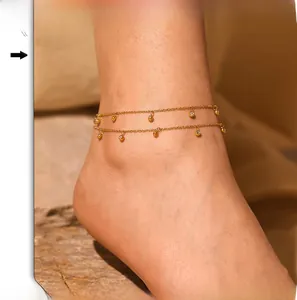Detailed view of double-layered gold anklet with polished beads and zircon accents