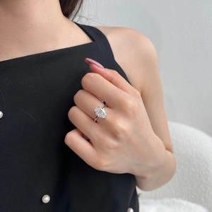 Detail view of a S925 silver ring featuring a large oval-cut sparkling gemstone on a finger