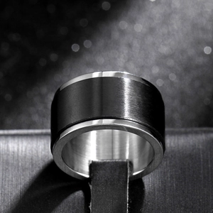 Close-up of 8mm black brushed stainless steel spinning ring for men on a display stand