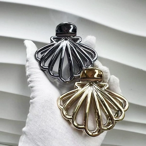 Detail of shell-shaped metal hair claws in gold and grey finishes with a glossy texture