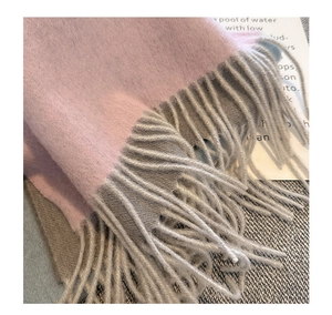 Detailed macro view of soft pink and grey water ripple pure cashmere wool scarf with tassels