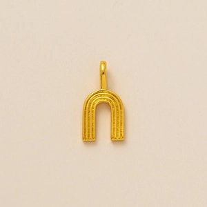 Macro detail of a golden textured U-shaped pendant with cubic zirconia for jewelry making