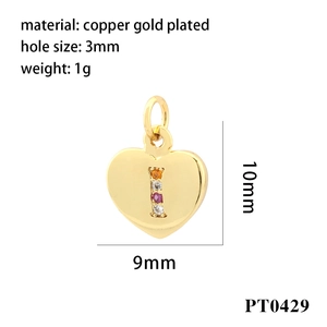 Dettaglio macro di un ciondolo a cuore in rame placcato oro 9x10mm con zirconi incastonati