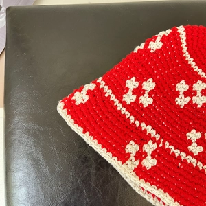 Close-up of red and white handmade crochet knit pattern with floral woven texture