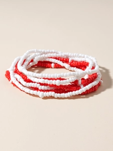 Detailed view of red and white multi-layered seed bead waist chain in a bohemian style