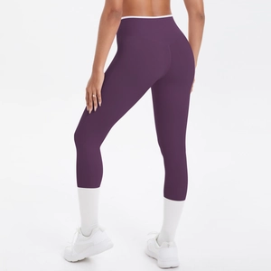 Détail du legging de yoga taille haute violet foncé avec bordure blanche et coupe de sport