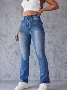 Detail of high waisted distressed blue jeans showing texture and vintage wash effects