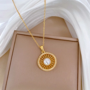 Detail view of gold titanium bird nest necklace with pearl center and diamond accents