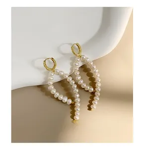 Detail of elegant S925 silver long drop earrings with white pearls and gold hoops