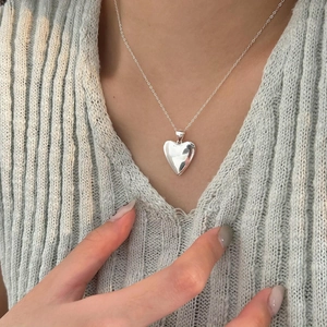Detailed view of polished sterling silver 3D heart pendant on a delicate chain necklace