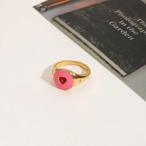 Detail of 18K gold stainless steel ring with red heart zircon and pink enamel inlay