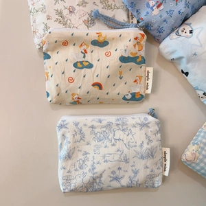 Flat lay of multiple cute cotton mini zipper pouches with animal patterns and branding