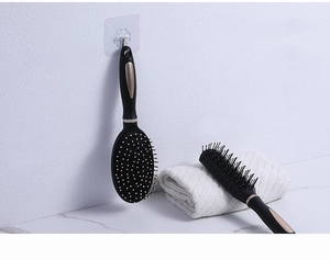 Detail view of black and gold anti-static air cushion and vented hair brushes on white marble