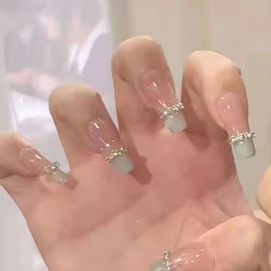 Détail de faux ongles carrés longs avec dégradé rose et vert et strass en cristal